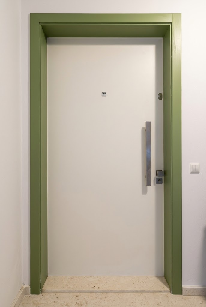 Modern flat entrance door with contrasting frame and vertical bar handle
