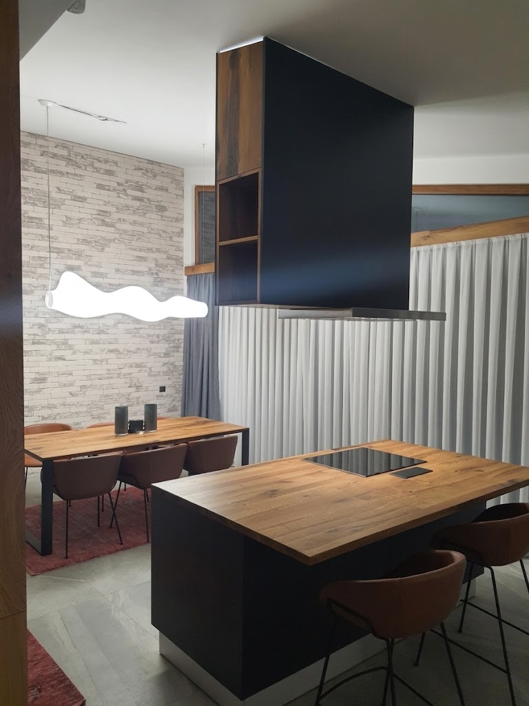 Modern industrial kitchen island with wood countertop, matte black base and overhead shelving