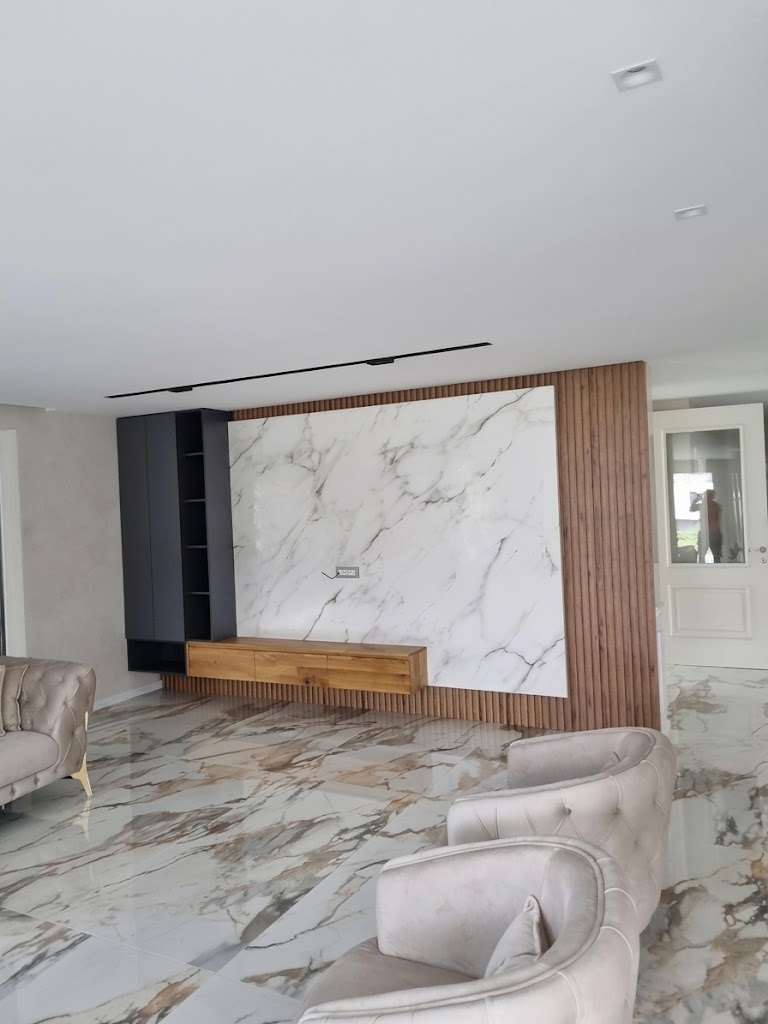 Marble and slatted wood wall paneling with a floating TV console and dark storage cabinetry